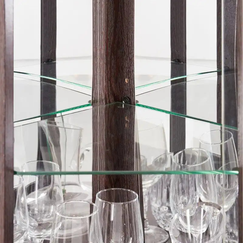 Vitrine d'angle élégante avec éclairage intégré, idéale pour mettre en valeur des objets de collection, de la verrerie ou des éléments de décoration.